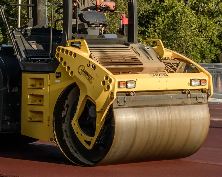 Close up view of a road roller compacting fresh asphalt | The Miller Group